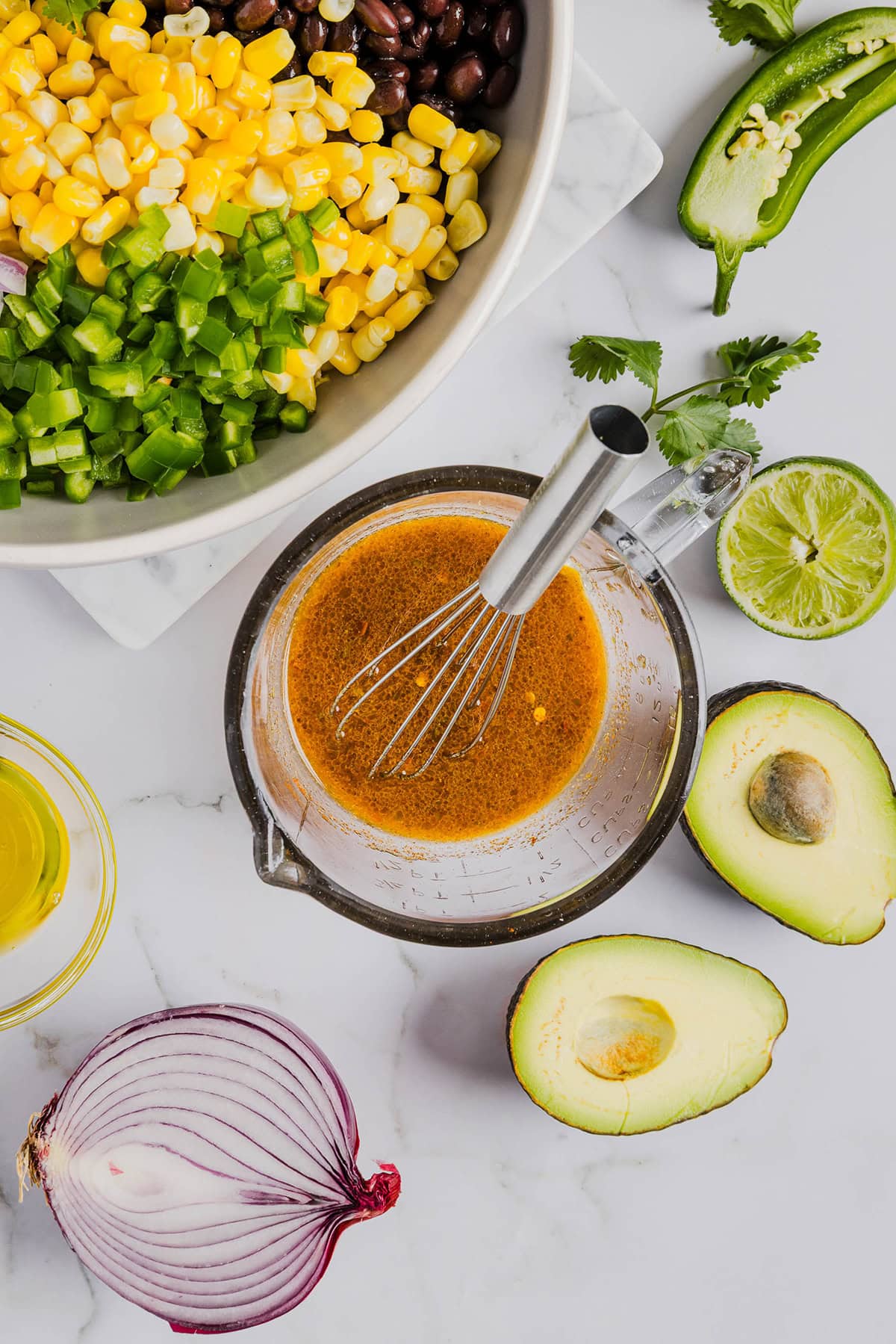 This Black Bean and Corn Salad is loaded with crisp veggies, delicious spices and fresh cilantro, all tossed together in a zesty lime dressing making it the perfect summer side dish or dip!