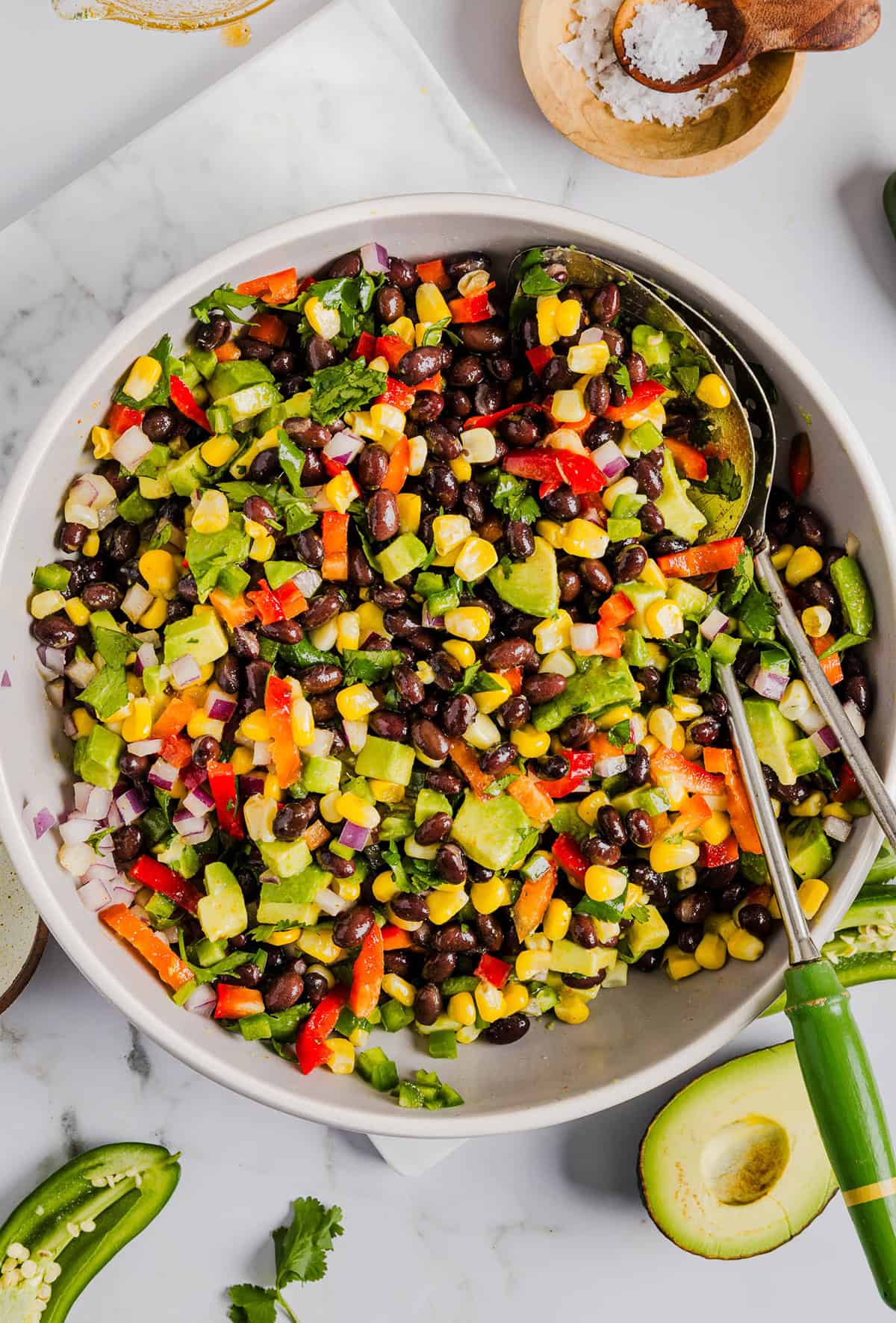 This Black Bean and Corn Salad is loaded with crisp veggies, delicious spices and fresh cilantro, all tossed together in a zesty lime dressing making it the perfect summer side dish or dip!